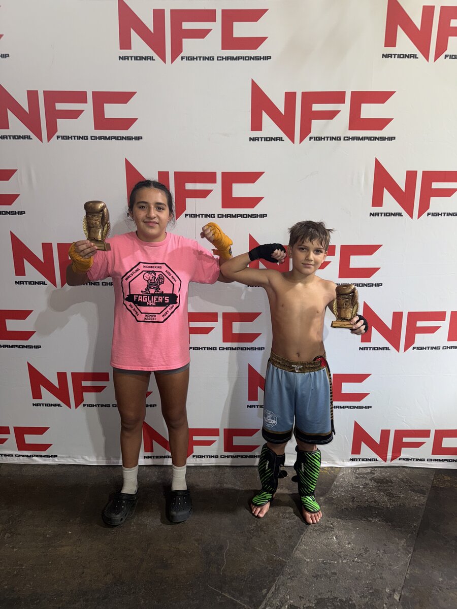 Two young Faglier's MMA students holding trophies at a National Fighting Championship event